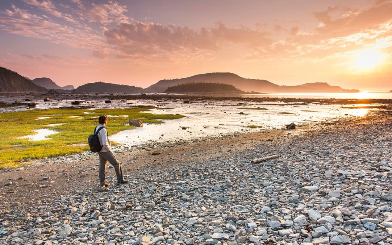 jeune homme qui marche dans le parc du Bic au coucher de soleil