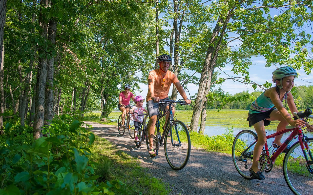 famille à vélo sur une piste cyclable dans le Parc du Bic