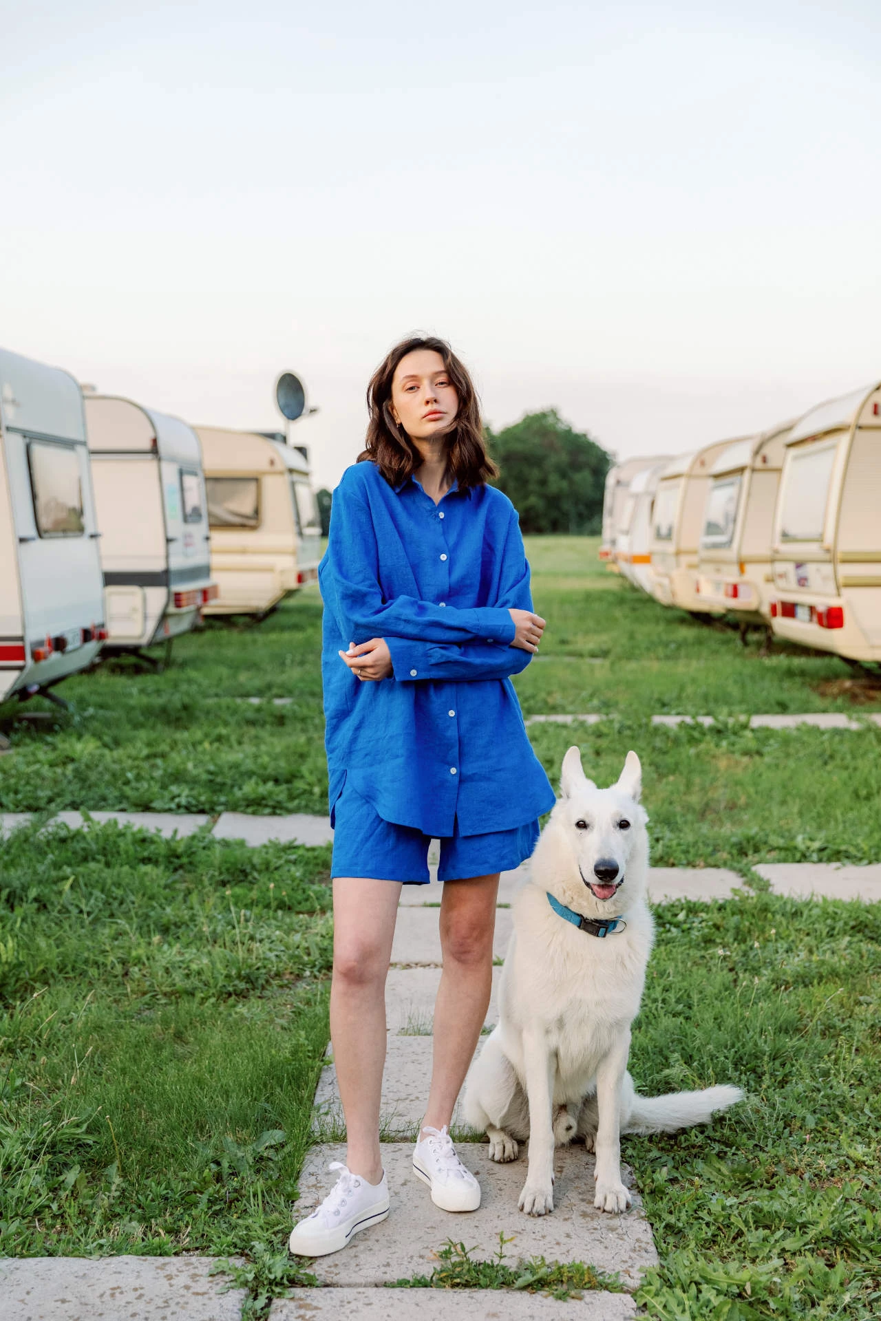 jeune femme debout avec son chien entre des rangées de roulottes