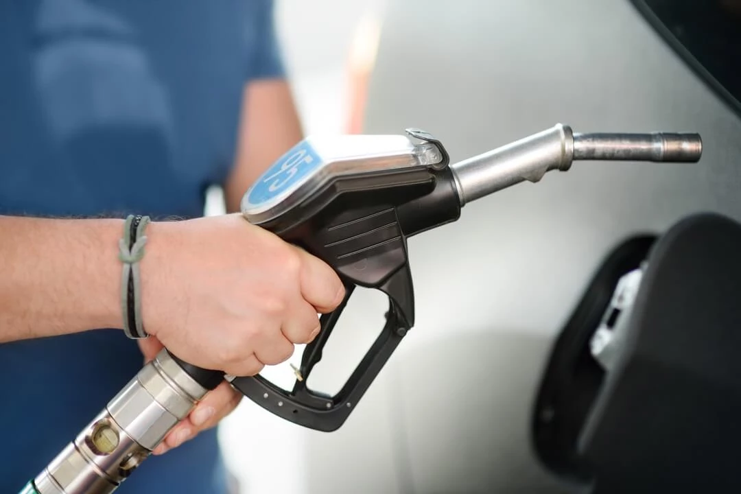 Homme remplissant de l'essence dans une voiture.