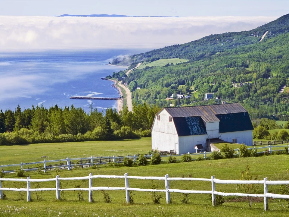 une ferme avec la route du Fleuve au loin