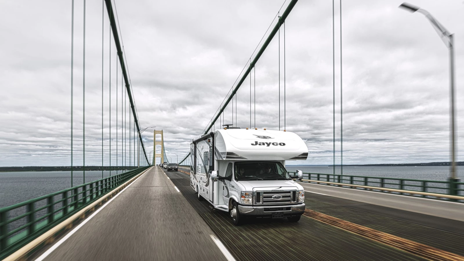 Vue 3/4 avant d'un véhicule récréatif du fabricant Jayco roulant sur un pont