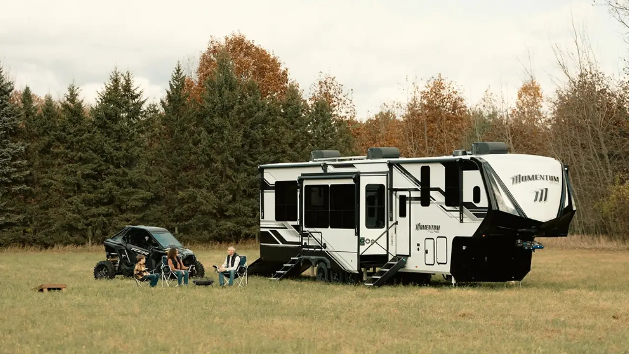 roulotte de type 5th wheel dans un champ avec des campeurs
