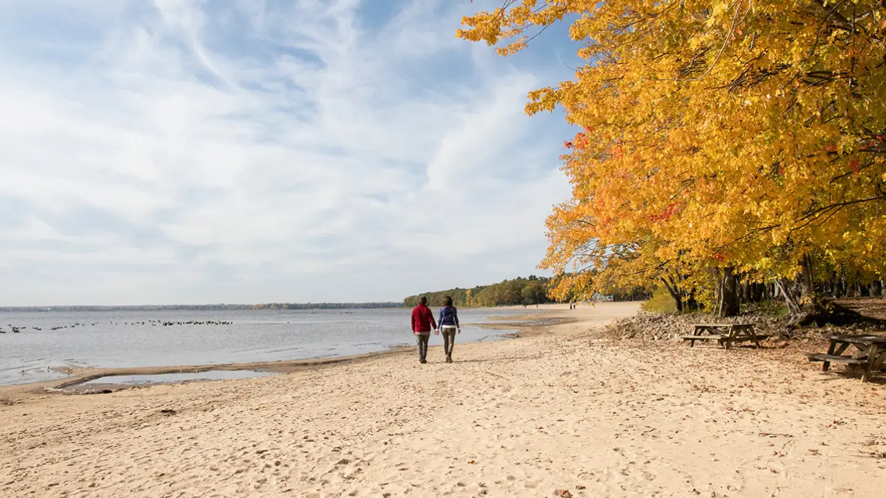 couple se promenant sur la plage d'Oka un jour d'automne