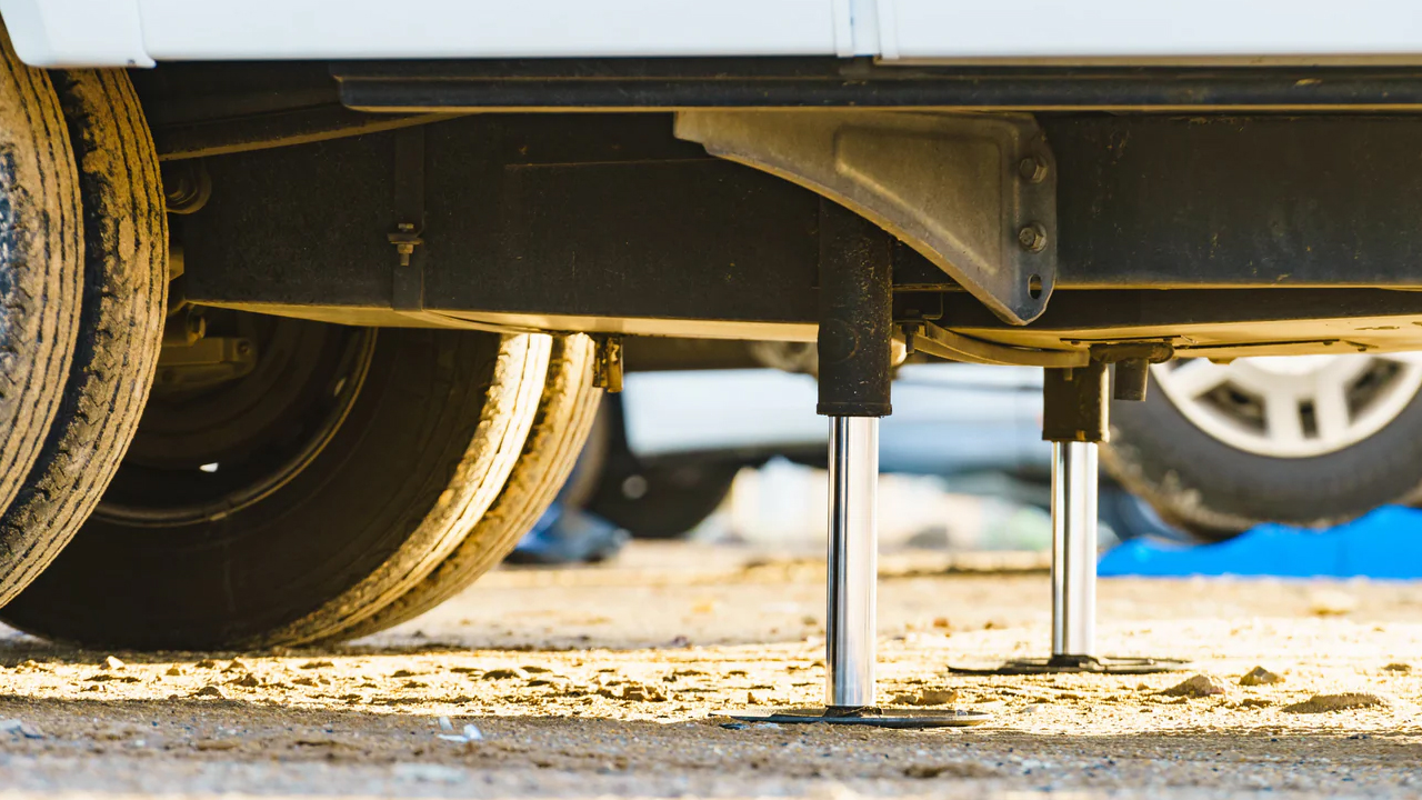 Vue en dessous d'une roulotte avec un système de stabilisateurs