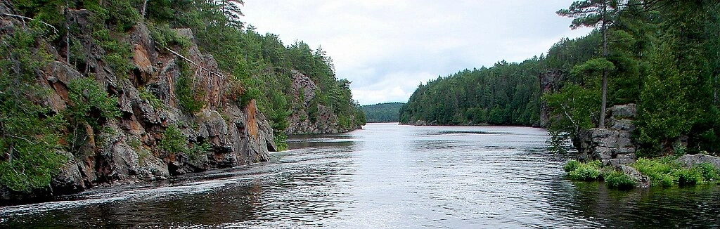 Vue paisible de la rivière Mattawa entourée de falaises boisées, illustrant une halte nature lors de l’étape Montréal à North Bay.