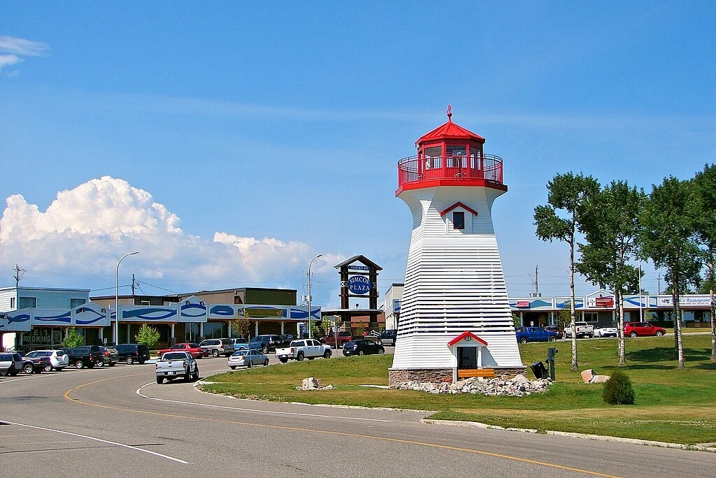 Phare rouge et blanc emblématique de Terrace Bay sous un ciel bleu, représentant une escale maritime pittoresque du voyage en VR.