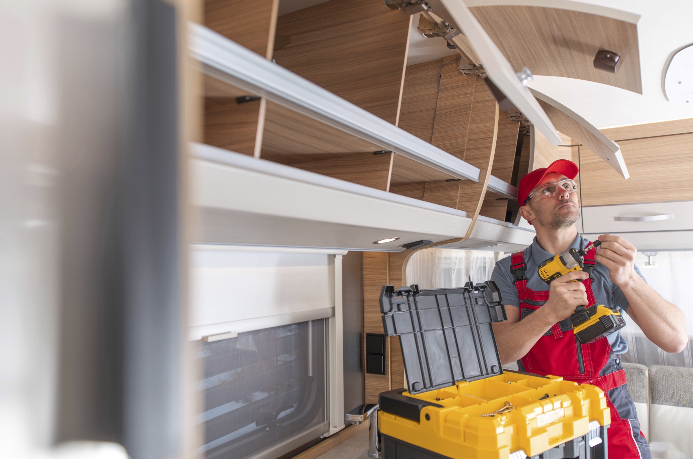 Un homme qui refixe des armoires.